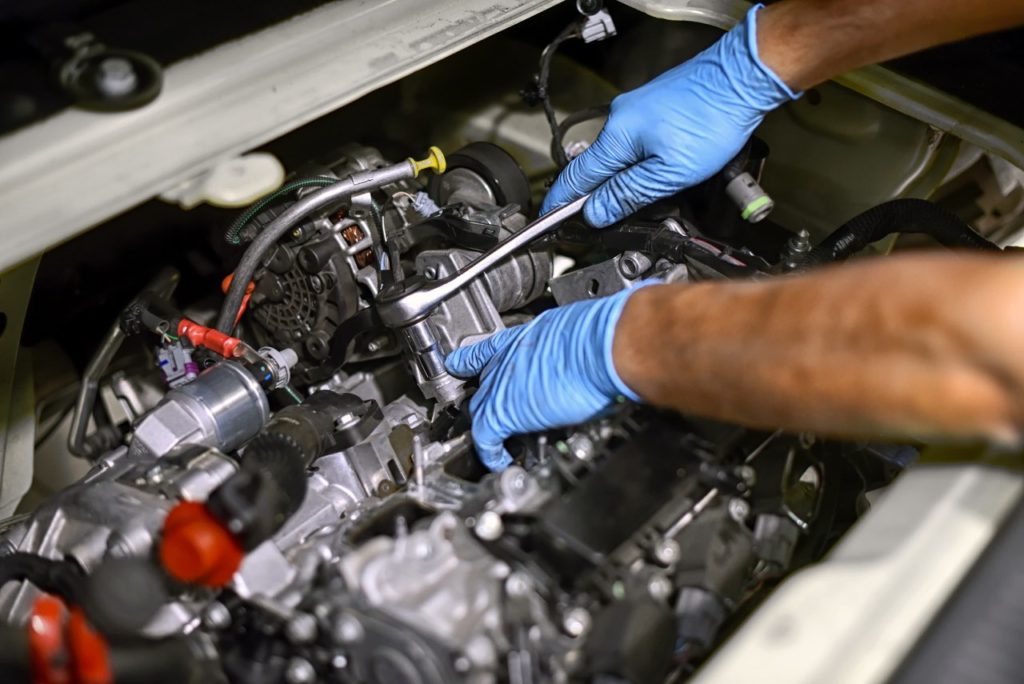 Auto Transmission Repair & Replacement Dubai - HanDs Of A Mechanic Working On A Car Engine P5KZ47G 1024x684